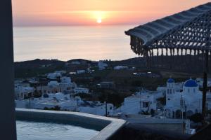 VourvoúlosにあるPanthea Suite Santorini - Private poolの夕日とともに市街の景色を望めます。