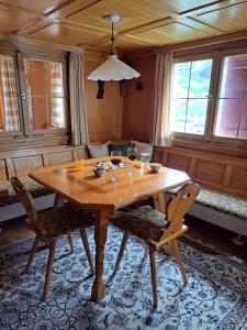 a wooden table with two chairs and wine glasses on it at Familienfreundliches Bregenzerwälderhaus in Au im Bregenzerwald
