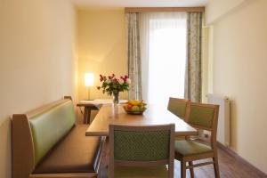 a dining room with a table with a vase of fruit on it at Kaiser-Franz in Bad Hofgastein