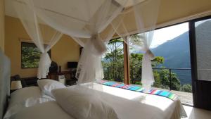 a bedroom with a bed with a large window at Casa Adobe Finca in La Peña