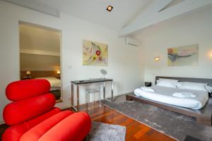 um quarto com uma cadeira vermelha e uma cama em Lafitenia Resort em Saint-Jean-de-Luz