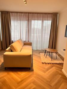 ein Wohnzimmer mit Sofa und Tisch in der Unterkunft Ostendeau - stijlvol appartement in hartje Oostende in Ostende