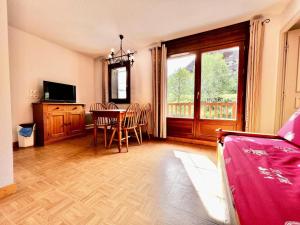 salon ze stołem, krzesłami i telewizorem w obiekcie Les Chalets Des Evettes - Agréable appartement au pied des pistes MAE-1724 w mieście Notre-Dame-de-Bellecombe