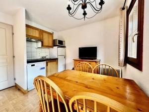 kuchnia z drewnianym stołem jadalnym i krzesłami w obiekcie Les Chalets Des Evettes - Agréable appartement au pied des pistes MAE-1724 w mieście Notre-Dame-de-Bellecombe