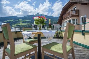 a table with a vase of flowers on a balcony at Kaiser-Franz in Bad Hofgastein