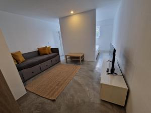 a living room with a couch and a television at Come Inn Sintra in Sintra