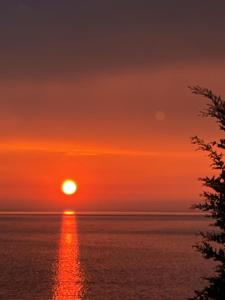 a sunset over the ocean with the sun in the sky at Bluemoon Suites Sarande in Sarandë