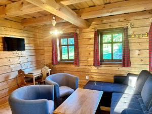 a living room with a couch and a table and chairs at Chalupy Březka in Libuň
