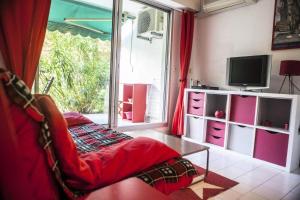salon z kanapą i telewizorem w obiekcie Villegiales Tee2 - En Rez de jardin dans une résidence avec piscine MAE-1154 w mieście La Grande-Motte