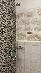 a shower in a bathroom with a stone wall at Eternia Suites in Katakoúli