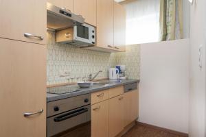 a small kitchen with a sink and a microwave at Kaiser-Franz in Bad Hofgastein