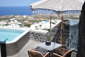 VourvoúlosにあるPanthea Suite Santorini - Private poolのテーブルと椅子と傘のあるパティオ