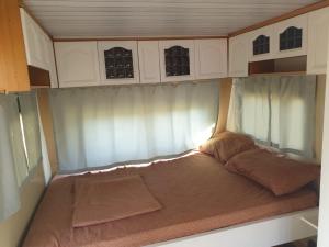 a small bed in the back of a rv at Aquariumi Jale Camping in Jal +18 photos