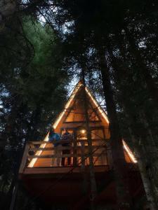 dos personas sentadas en la cubierta de una casa del árbol en Bude Mestia cottages, en Mestia