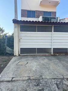 eine Garagentür an der Seite eines Hauses in der Unterkunft Casa Aconchego 6min basílica in Aparecida