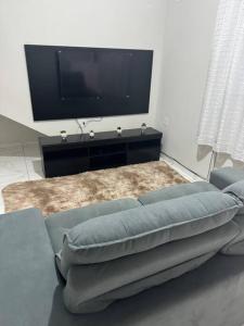 ein Wohnzimmer mit Sofa und Flachbildfernseher in der Unterkunft Casa Aconchego 6min basílica in Aparecida