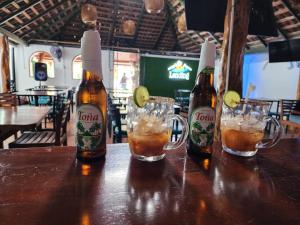 three bottles of beer sitting on a table at The Landing Hotel And Restaurant in Moyogalpa