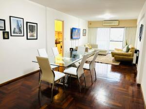 a living room with a glass table and chairs at Céntrico y amplio departamento en La Cañada in Cordoba