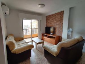 ein Wohnzimmer mit zwei Sofas und einem Fernseher in der Unterkunft Piso cerca Playa con 2 duchas y 5 Aires Acondicionados in Almería