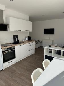 a kitchen with white cabinets and a table and chairs at RK Apartment Brno in Brno