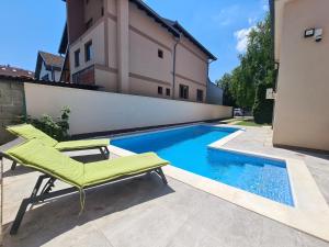 a green chair sitting next to a swimming pool at House Reko in Novi Grad