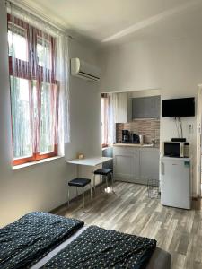 a room with two beds and a table and a kitchen at Holdfény apartman in Siófok +19 photos