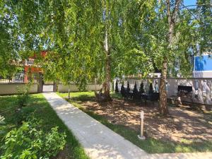 a park with chairs and trees and a sidewalk at House Reko in Novi Grad