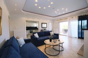 a living room with a blue couch and a table at Nerea Apartments in Agios Ioannis Kaspaka