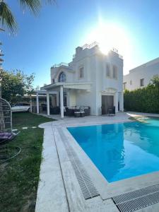 Una casa grande con piscina delante de ella. en Bodrum Villa Dilayla, en Bodrum City
