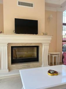 Una sala de estar con chimenea y un televisor de pantalla plana. en Bodrum Villa Dilayla, en Bodrum City