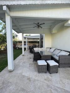 un patio cubierto con sofás, mesa y sillas en Bodrum Villa Dilayla, en Bodrum City