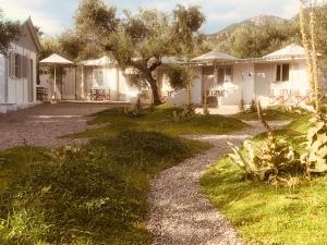 a house with a tree and a gravel driveway at Barreira Beachfront Rooms 4 in Kalamata
