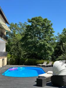a swimming pool with two lounge chairs next to a house at Ferienwohnung Panorama Oberkirn in Oberkirn