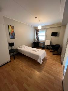 a bedroom with a bed and a table in a room at Hostelli Palonkortteeri in Ilmajoki