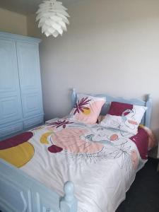 una camera da letto con un letto con lenzuola bianche e cuscini colorati di Maison à Gimel les Cascades en Corrèze a La Bitarelle