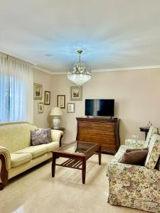 a living room with a couch and a tv at Chalet adosado en Nantes Sanxenxo in Sanxenxo