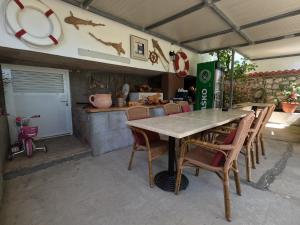 a table and chairs in a kitchen with a counter at Apartmani Daniela in Rab