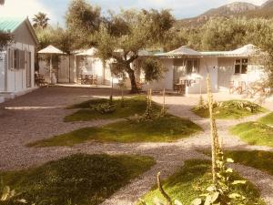 a house with a yard with trees and a building at Barreira Beachfront Rooms 7 in Kalamata