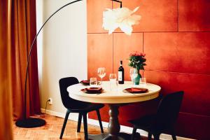 a table with wine glasses and a vase of flowers at Stanislawa Augusta by P&J Apartments in Warsaw