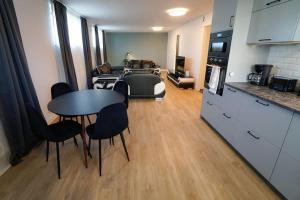 a kitchen and a living room with a table and chairs at Lägenhetshotell i Sveg in Sveg