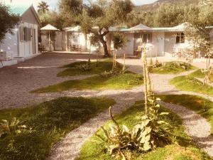a garden with some plants and a house at Barreira Beachfront Rooms 7 in Kalamata