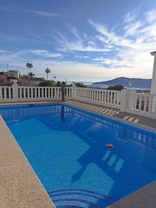 a large blue swimming pool with a white fence at Villa Panoramica / La Nucia (Costa Blanca) in La Nucía