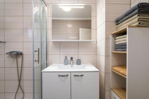 a bathroom with a white sink and a shower at App D Comfort in Umag +19 photos