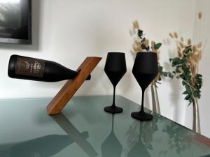 two black wine glasses sitting on a glass table at HARMONY "2" stylishes 2 Zimmer Apartment 1 OG Balkon Garten Parkplatz in Gütersloh