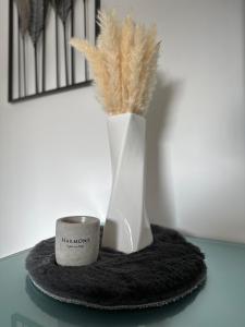 a candle and a vase with feathers in it on a table at HARMONY "2" stylishes 2 Zimmer Apartment 1 OG Balkon Garten Parkplatz in Gütersloh