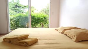 a bed with two towels on it with a window at Loue maison 10 couchages à La Rochelle avec jardin, proche plage in La Rochelle
