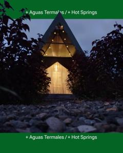 uma pequena casa com um telhado triangular com luzes em Flora Glamping de Abuela em Fortuna