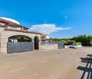 a car parked in front of a building with a gate at App D Comfort in Umag