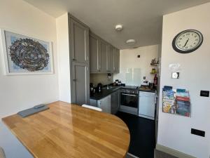 a kitchen with a wooden table and a clock on the wall at The Nook Castle Street Ludlow in Ludlow