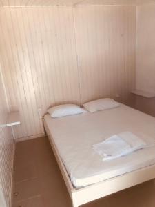 a small room with a bed with two white pillows at Barreira Beachfront Rooms 6 in Kalamata